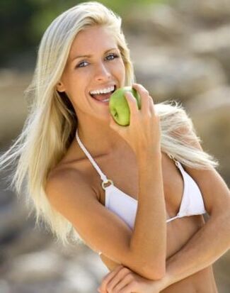 Une fille mange une pomme pour perdre 10 kg par mois